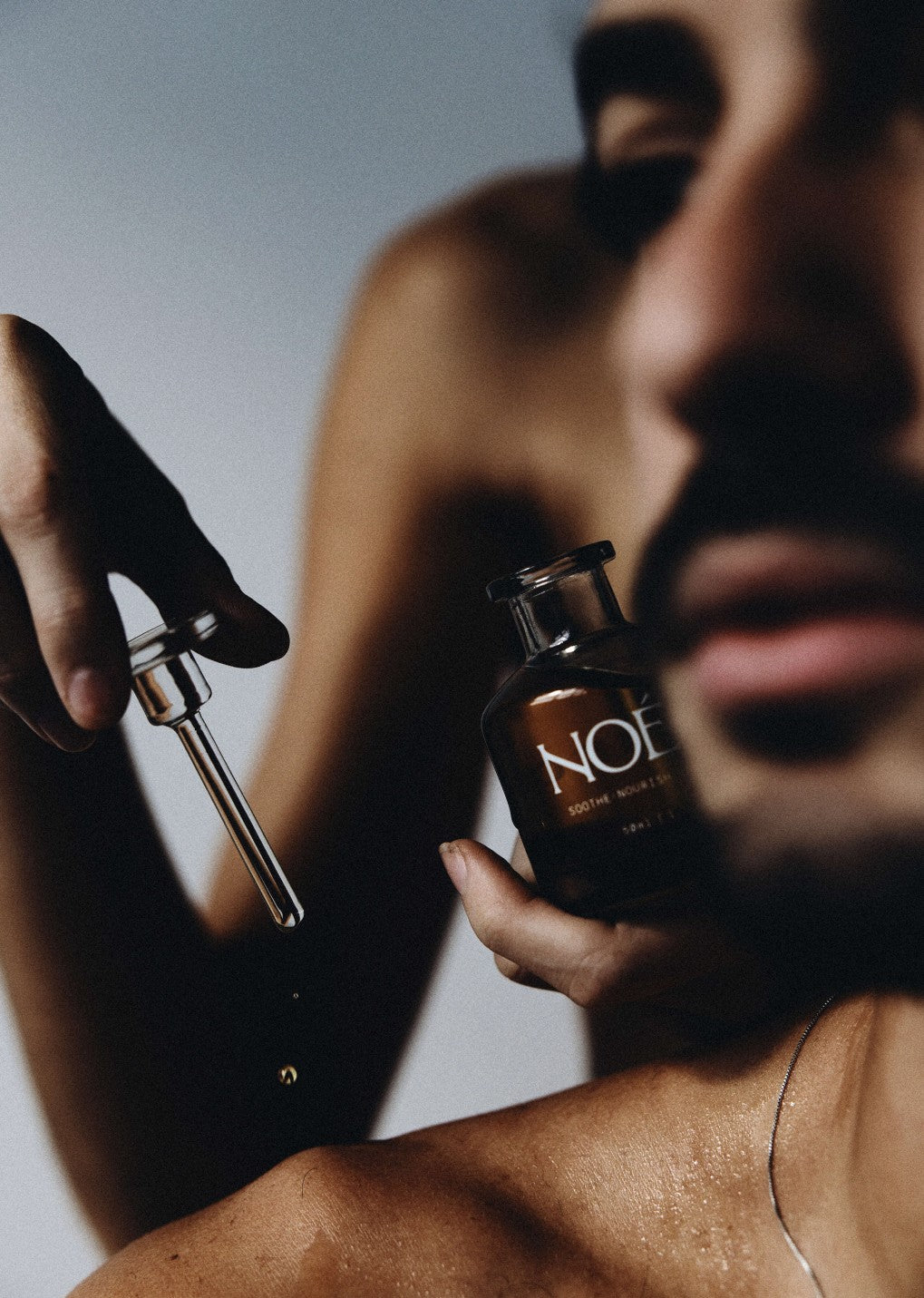 Man applying Nile Oil with a glass dropper