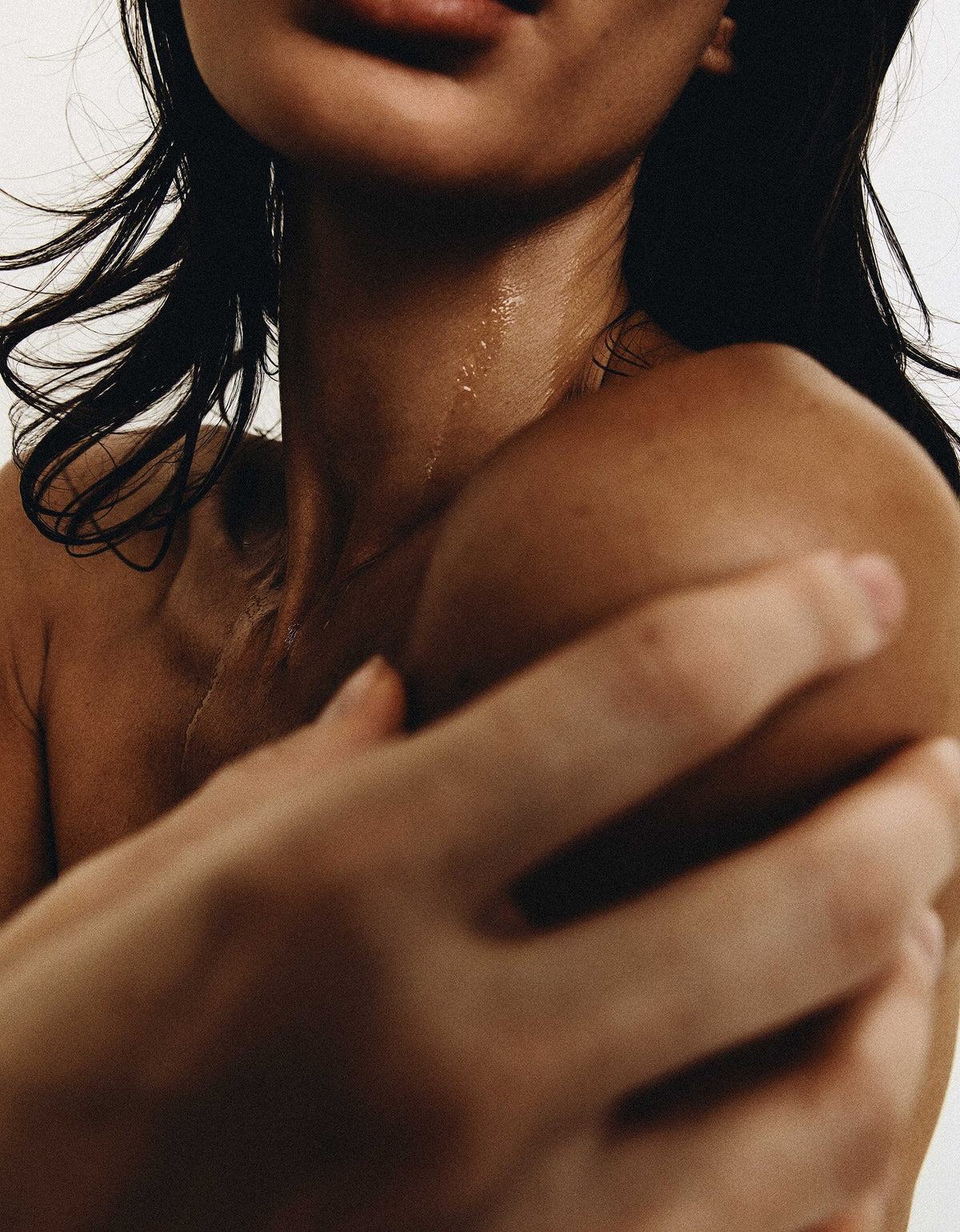 Woman with wet hair holding her shoulder